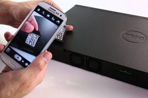 Una persona que usa un teléfono celular para tomar una fotografía de una computadora portátil Dell.